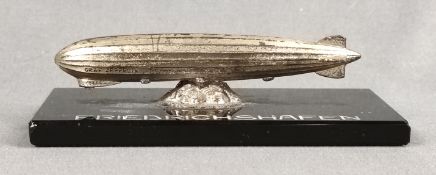 Zeppelin-Miniatur, auf rechteckiger Basis mit Schriftzug "Friedrichshafen", versilbert, Maße 3x10x5