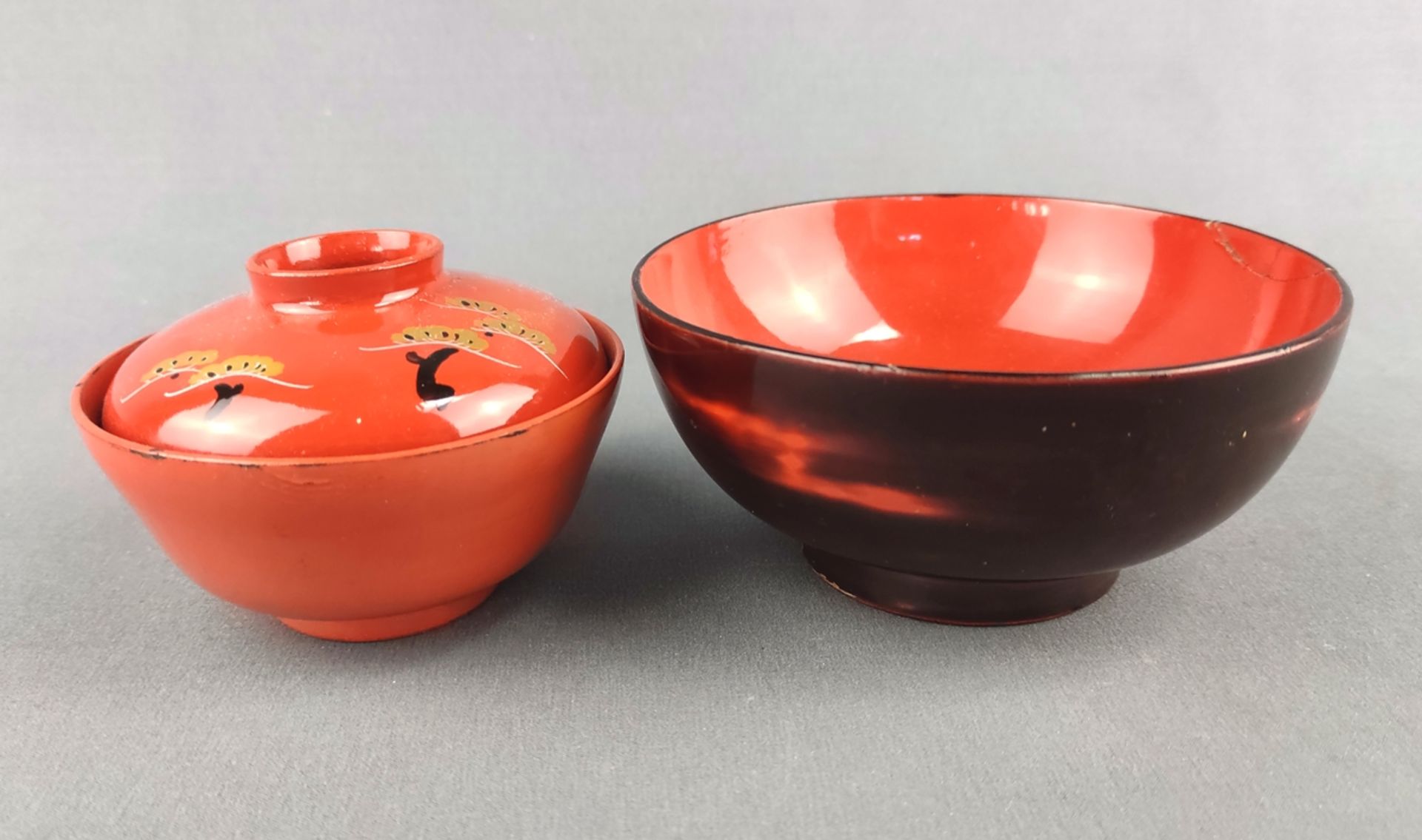 Two bowls / rice bowls, lacquered in red, consisting of a bowl with lid, decorated with cranes and 