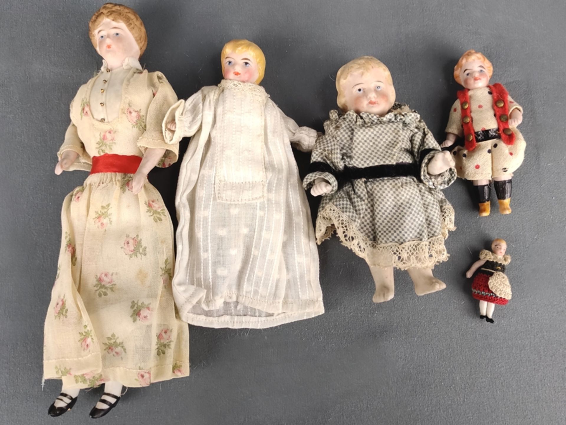 Konvolut kleine Porzellanpuppen, 5 Stück, bestehend aus: Dame in geblümten Kleid, Kopf, Arme sowie 