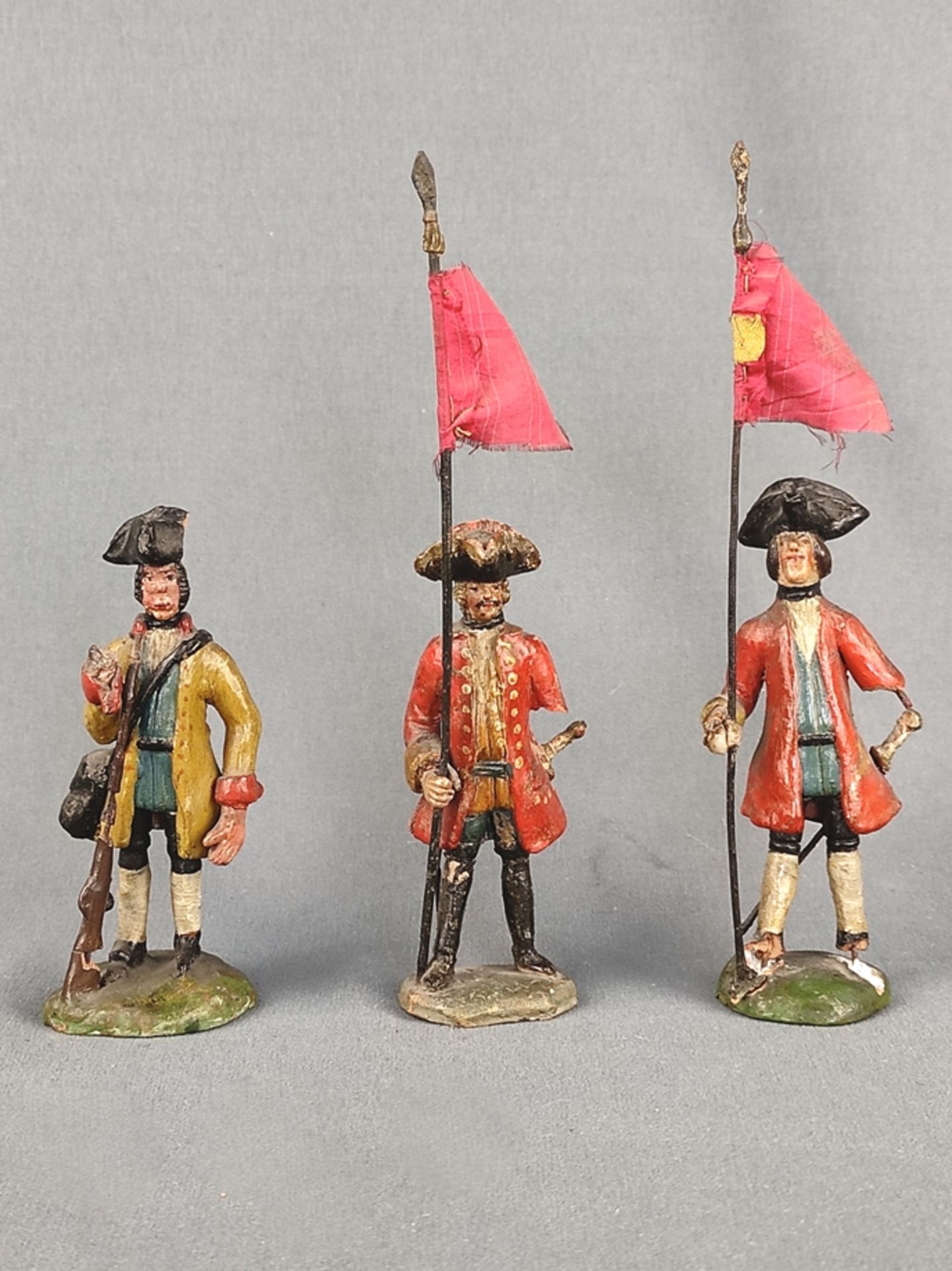 Drei Soldatenfiguren, 19. Jahrhundert, Terrakotta, farbig bemalt, Höhe (mit Flaggen) 17cm, teilweis