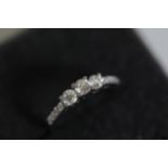 A 3 stone diamond ring cathedral set with diamond shoulders