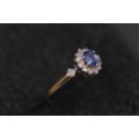 Oval sapphire in diamond cluster set in 9ct yellow gold with diamond should