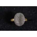 A large oval pave set diamond ring in 18ct yellow gold