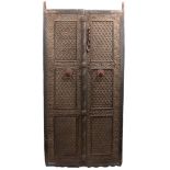 A PAIR OF 17TH CENTURY MUGHAL INDIAN CARVED HARDWOOD DOORS, each with three panels of flowerheads,