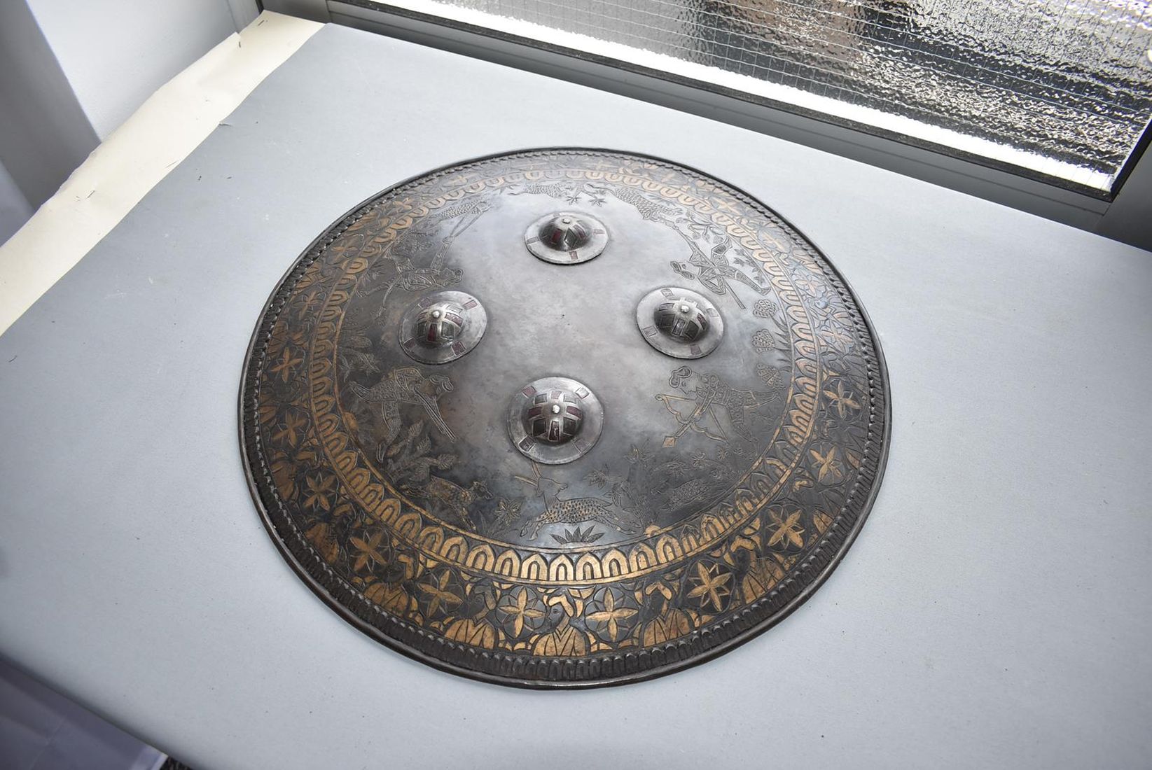 A SIKH INFLUNCED SHIELD OR DHAL, 44cm diameter steel body decorated with hunting scenes amidst - Image 2 of 9