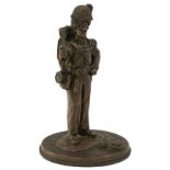 A BRONZED RESIN FIGURE OF A SERGEANT OF THE ROYAL WELSH FUSILERS, in full kit, holding a sergeant'