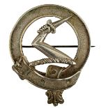 A SCOTTISH CLAN OFFICER'S BROOCH, of cast white metal, outer garter with central raised arm and