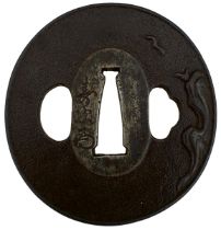 A CIRCULAR IRON TSUBA, decorated with a bird in flight over a rocky landscape, signed Toshitsugu