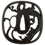 AN IRON SUKASHI TSUBA, chiselled and pierced with a dragon, in wood box, 7.4cm.