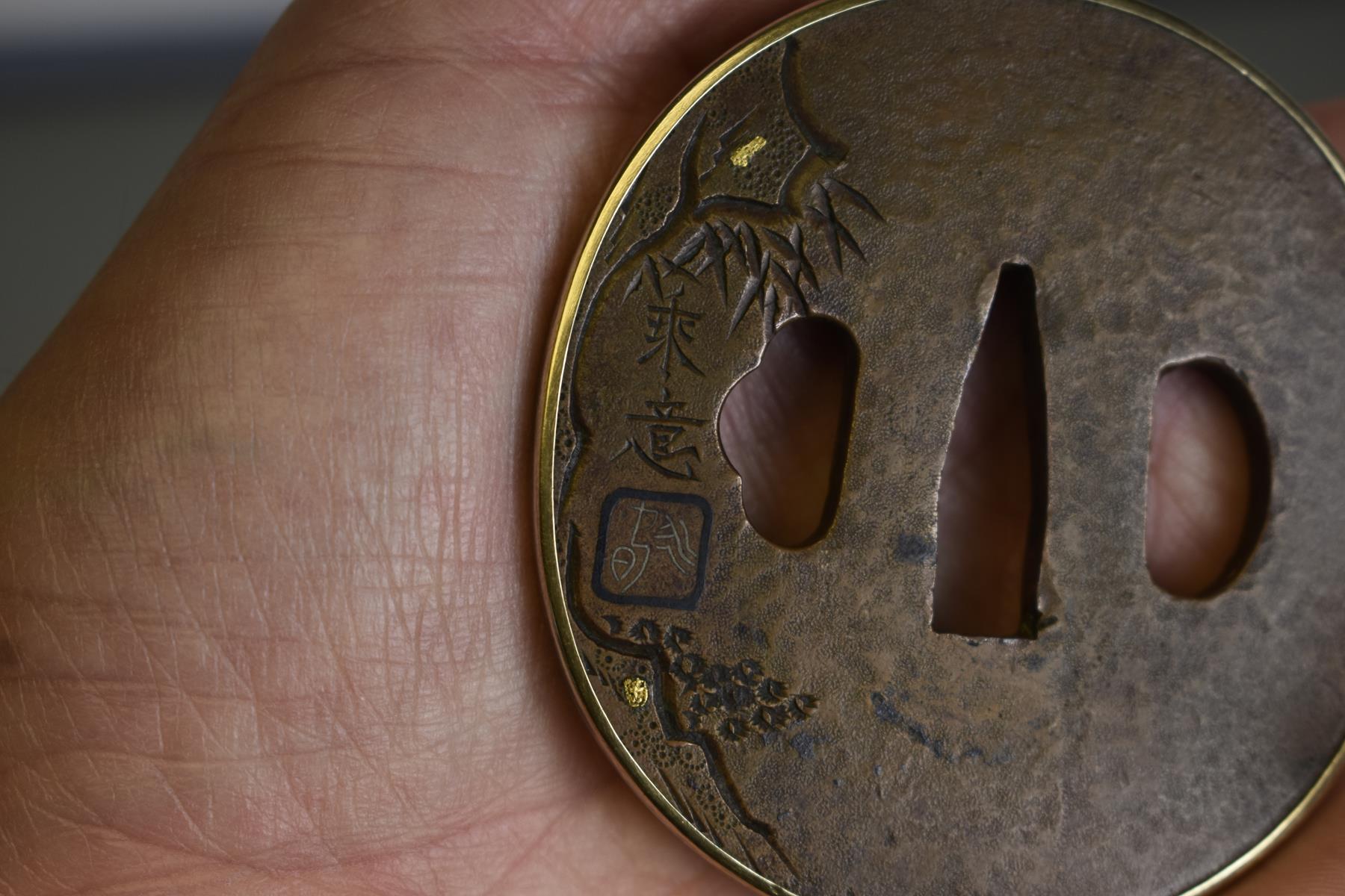 A CIRCULAR COPPER TSUBA, decorated with a figure in a cave within a landscape, gold and shakudo - Image 5 of 5