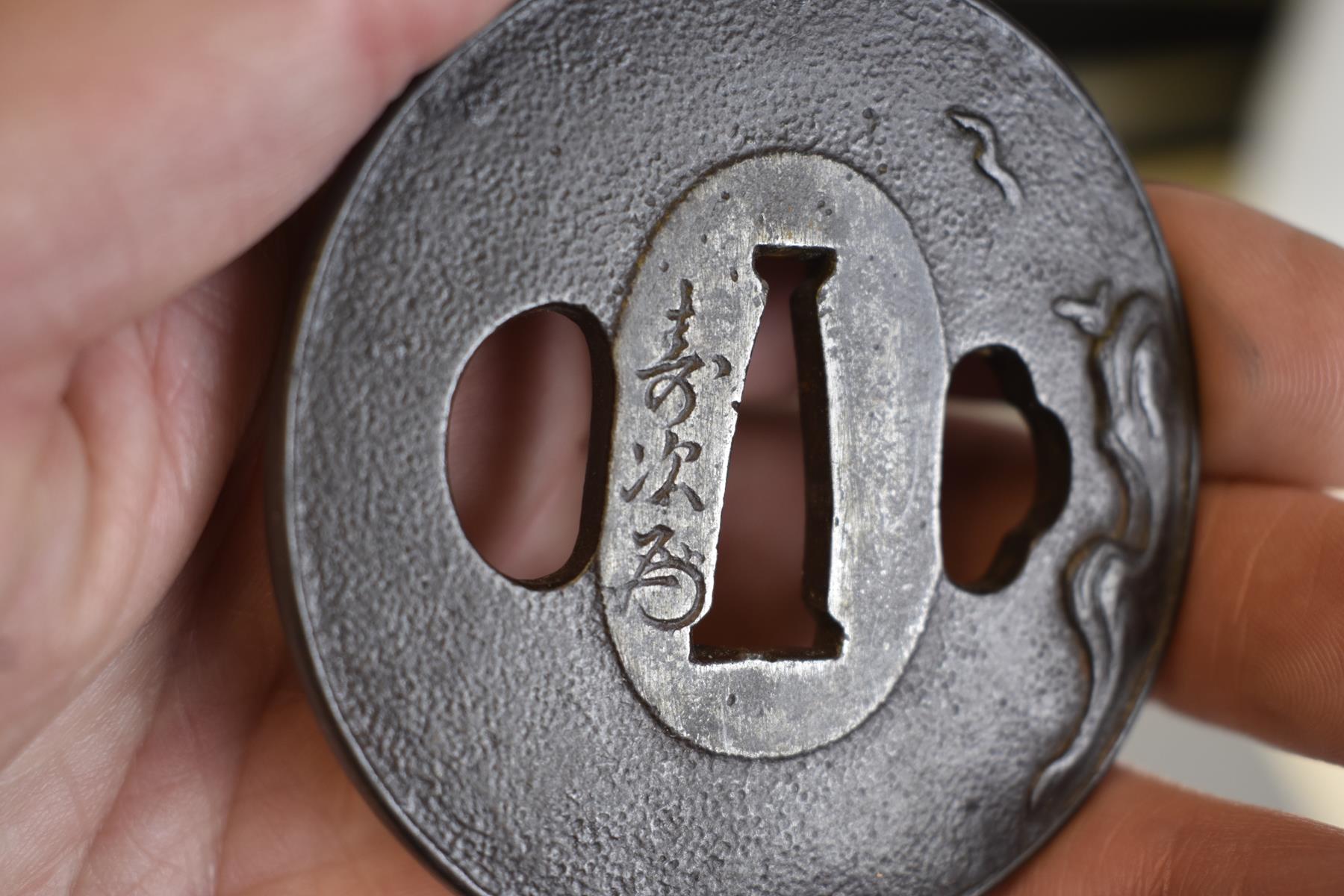 A CIRCULAR IRON TSUBA, decorated with a bird in flight over a rocky landscape, signed Toshitsugu - Image 4 of 5