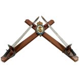 A NAVAL ARMAMENT SUPPLY DEPARTMENT MOUNTED CREST AND CUTLASSES, the mahogany crosspiece with painted