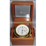Uhren. Wempe - Schiffschronometer in einem Holzkasten mit vollkardanischer Aufhängung. Originales