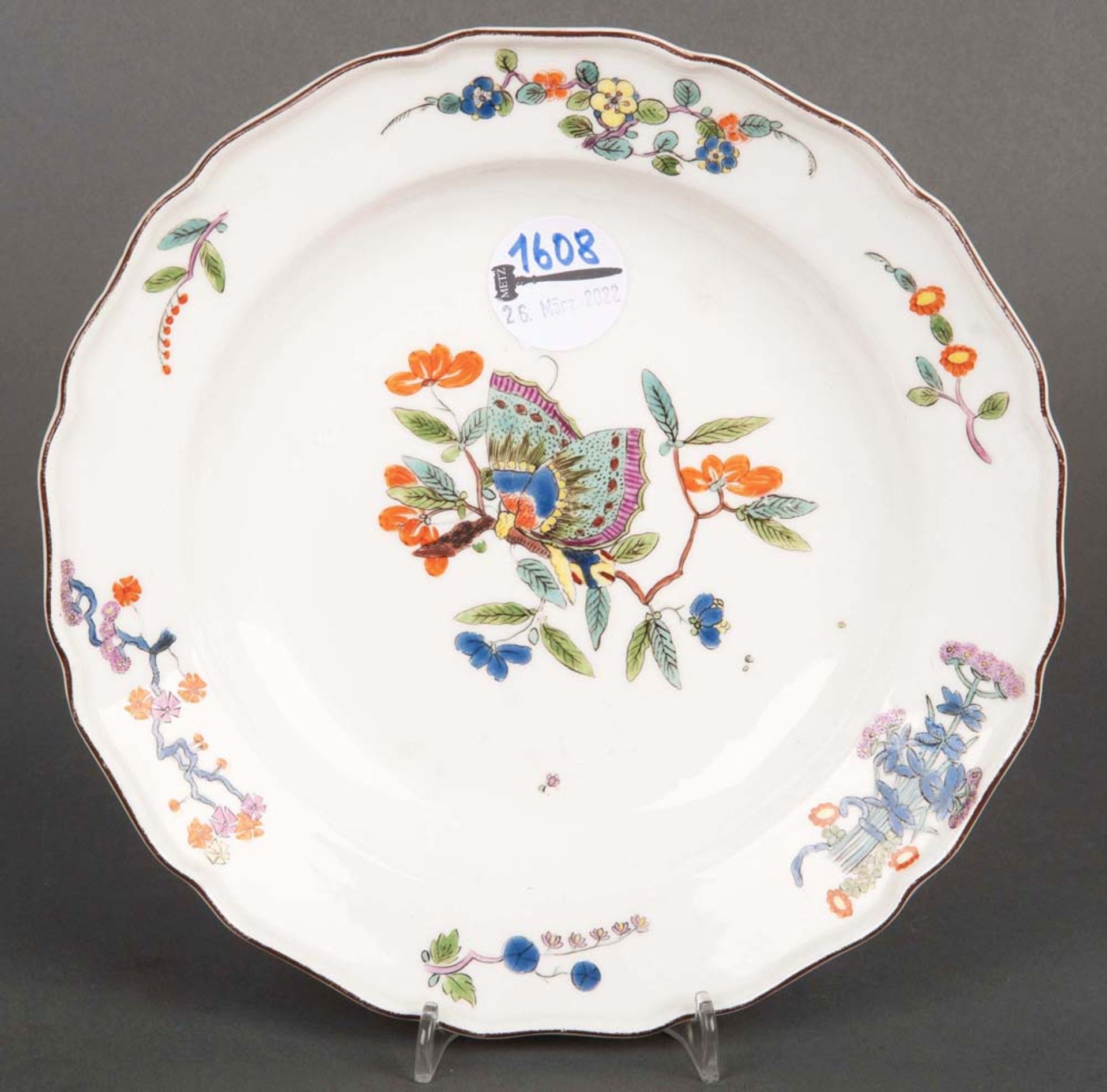 Teller. Meissen 1735. Porzellan, bunt bemalt mit Schmetterling- und Floraldekor und kapuzinerbrauner