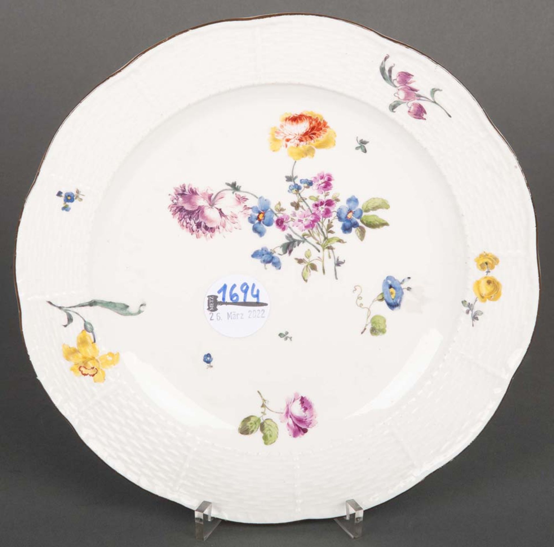 Teller „Ozierrelief“, Meissen 1750. Porzellan, bunt floral bemalt mit kapuzinerbraunem Lippenrand.