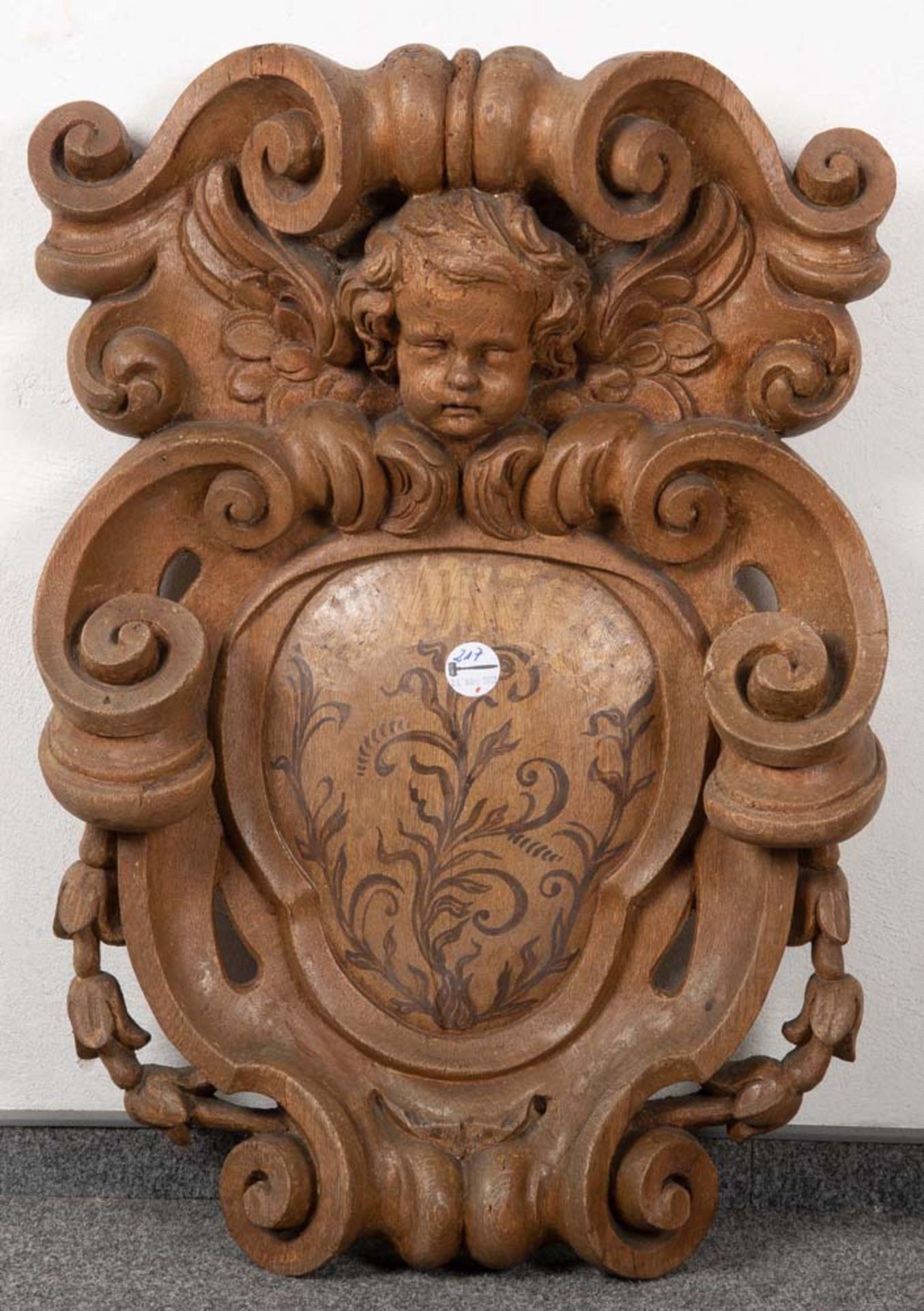 Großes Wappenschild. Deutsch 18./19. Jh. Eiche, reich geschnitzt, bekrönt von Putto, H=70 cm, B=48