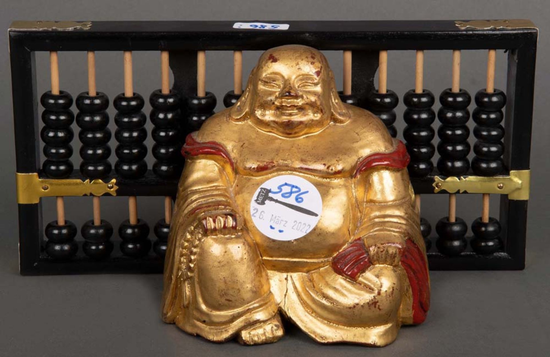 Buddha. Asien. Massivholz, geschnitzt und gold gefasst; dazu Rechenschieber, H=2,5 cm / L=11,5 cm.