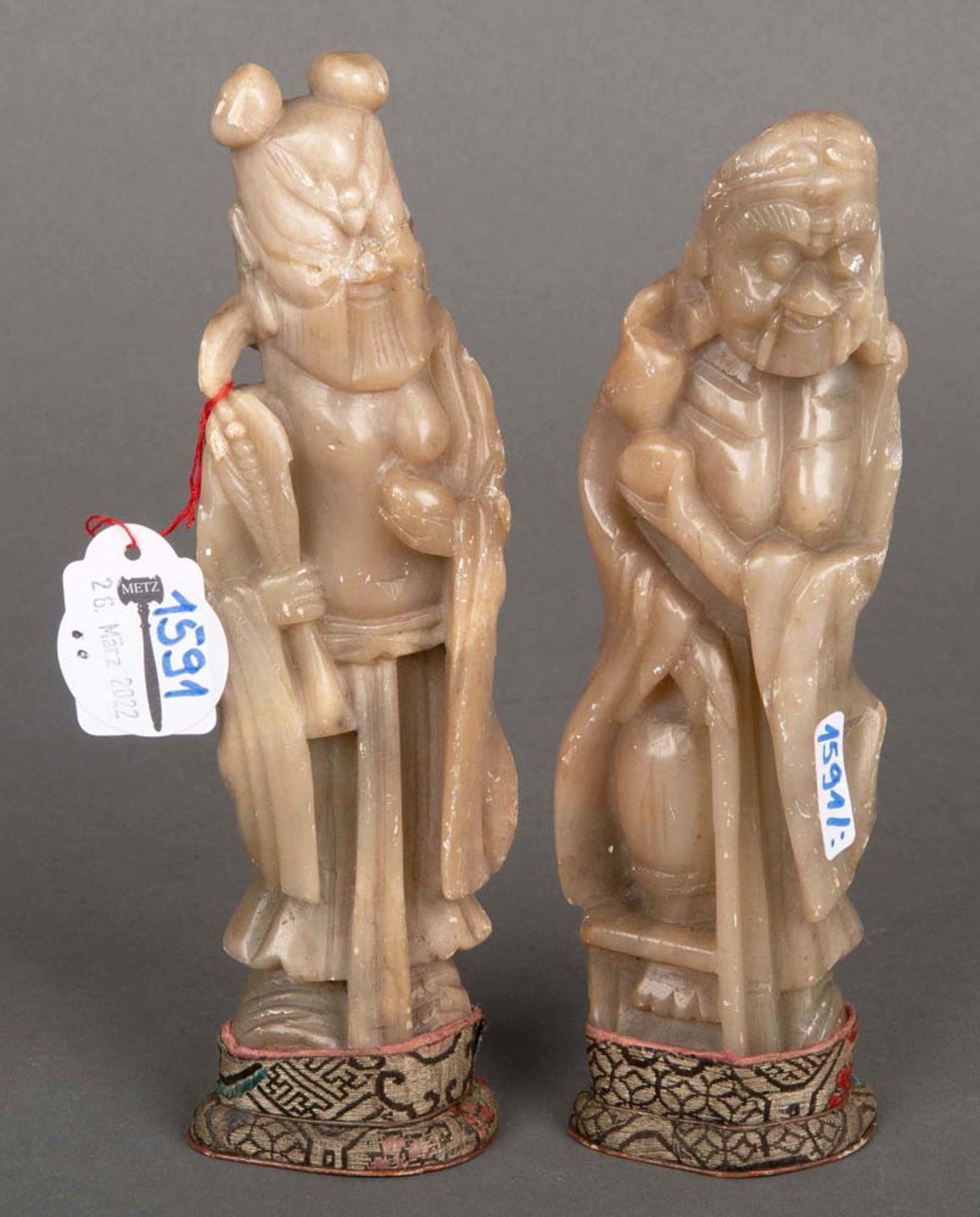Zwei Specksteinfiguren auf Sockel. Asien, H=18,5 cm bzw. 19 cm. (besch.)