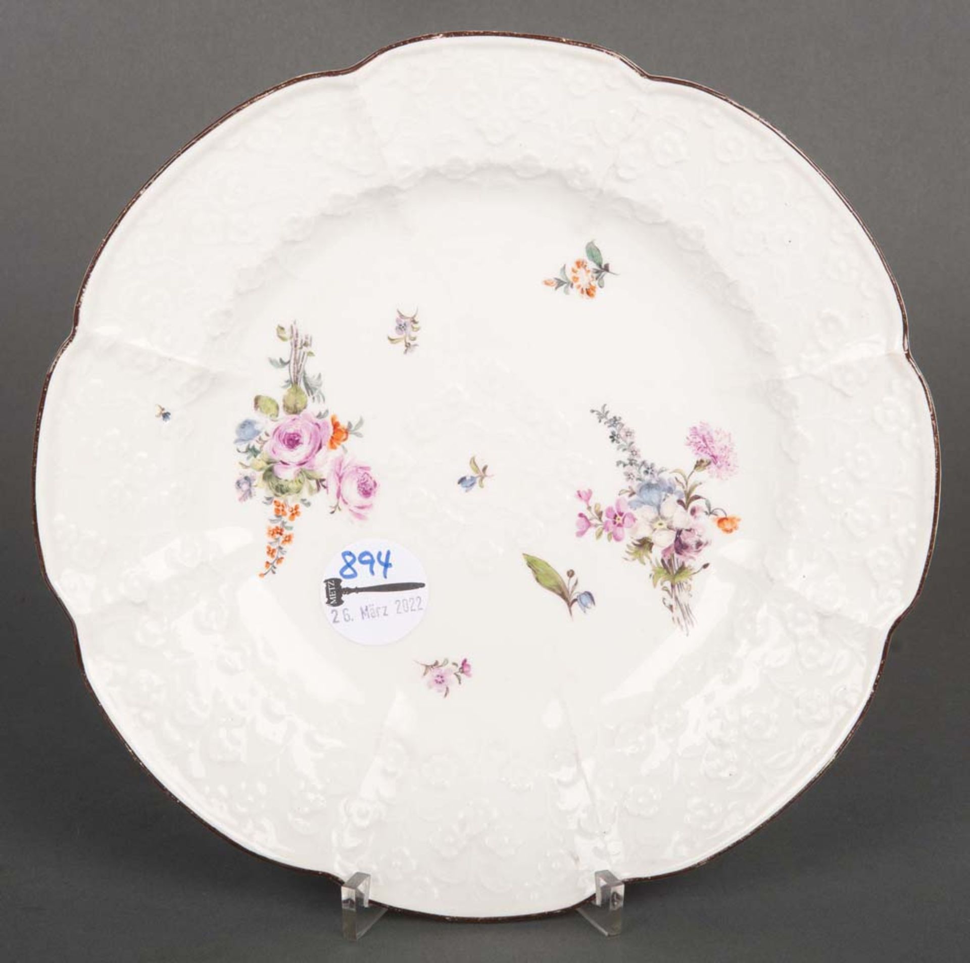 Teller. Meissen 1750. Porzellan mit Reliefblüten, Freiräume bunt bemalt mit Floraldekor. Verso