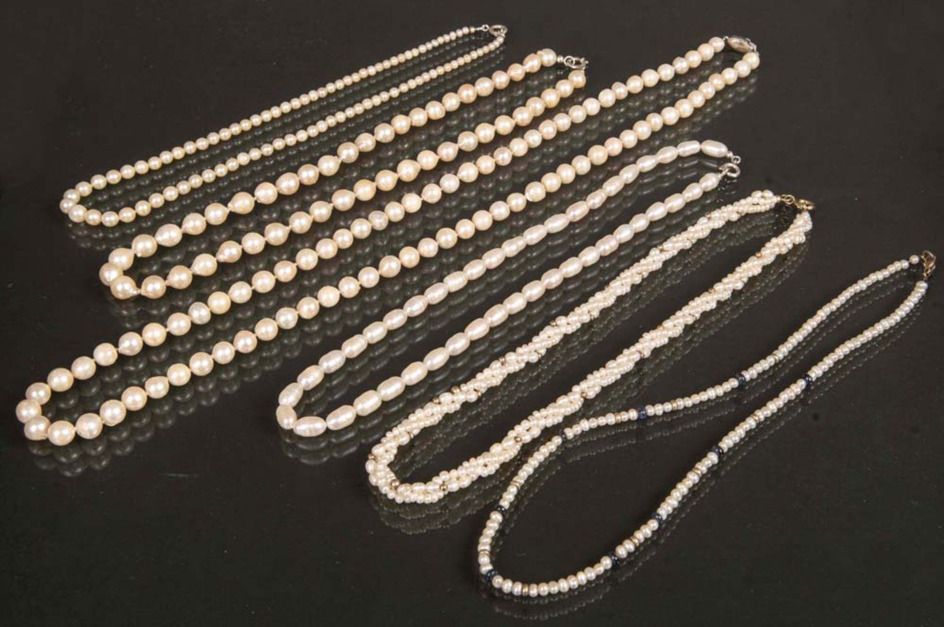 Sechs Perlenketten. Teils mit Silberverschluss.