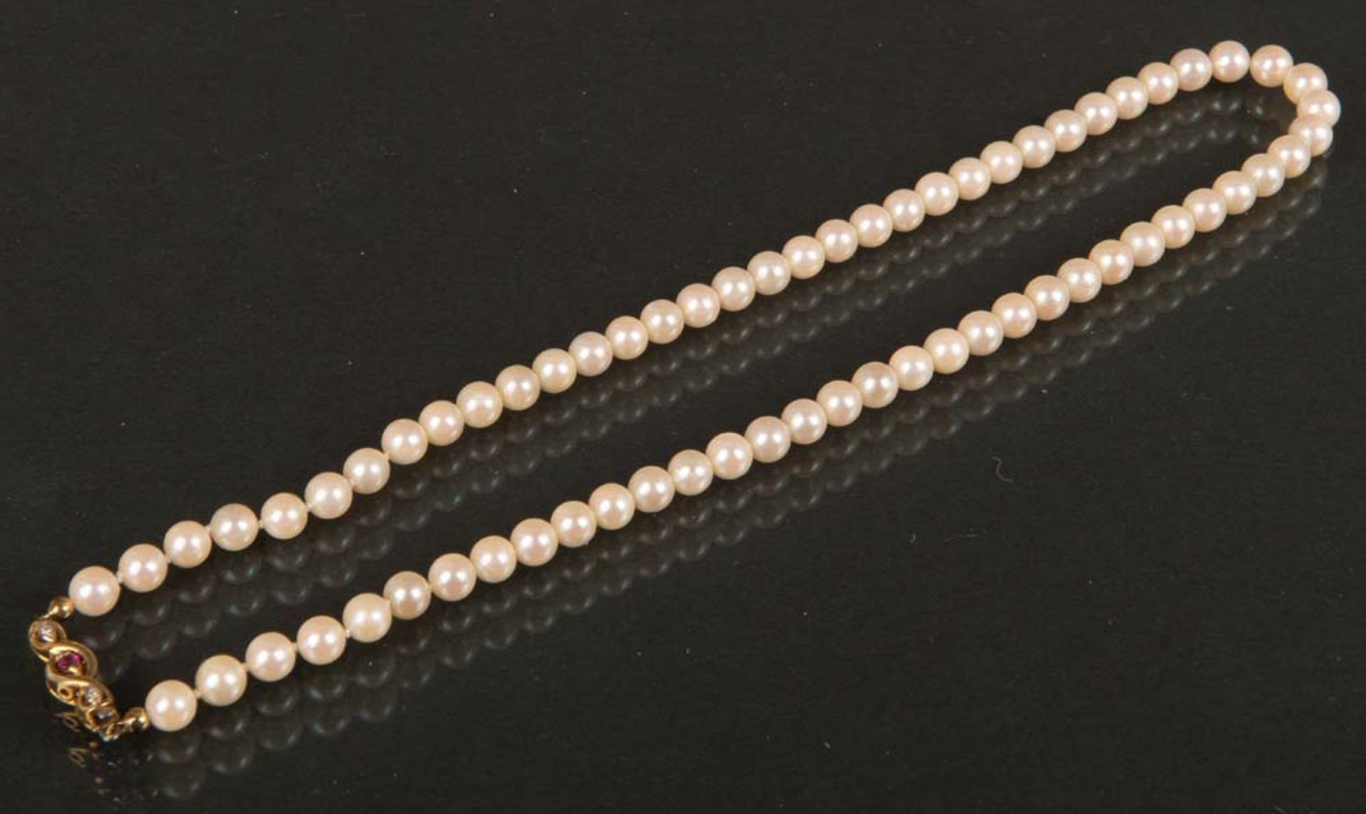 Perlenkette. 14 ct Goldverschluss, besetzt mit Brillanten, ca. 0,02 ct und Rubin.