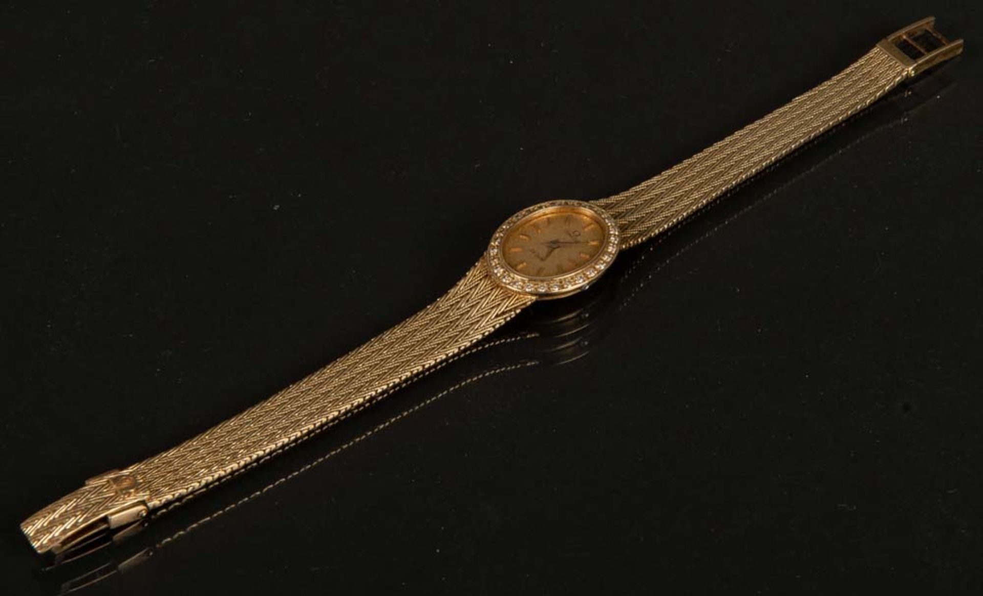 Damenarmbanduhr. 14 ct Gold, ca. 29 g, Marke Omega De Ville, besetzt mit Brillant, ca. 0,28 ct,