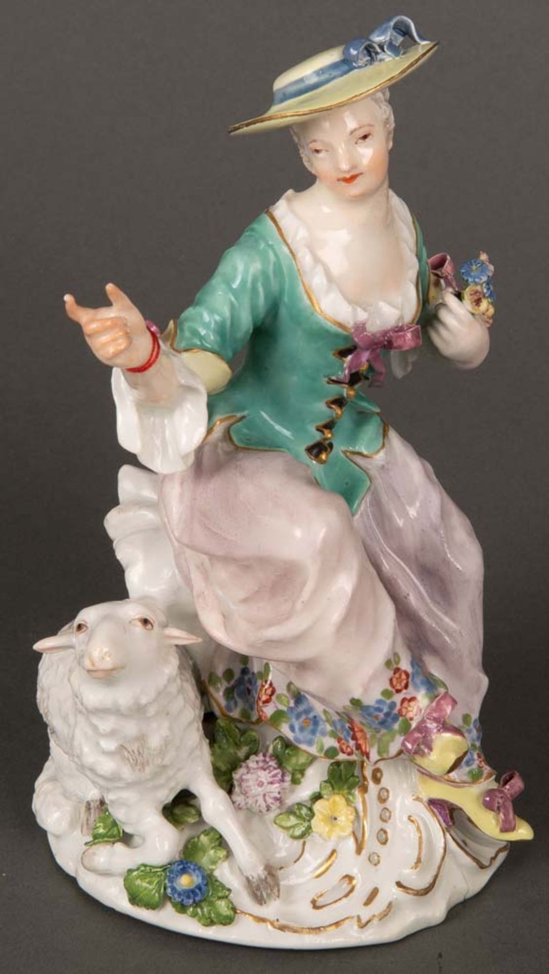 Sitzende Schäferin. Meissen 1745. Porzellan, bunt bemalt, verso unterglasurblaue Schwertermarke.