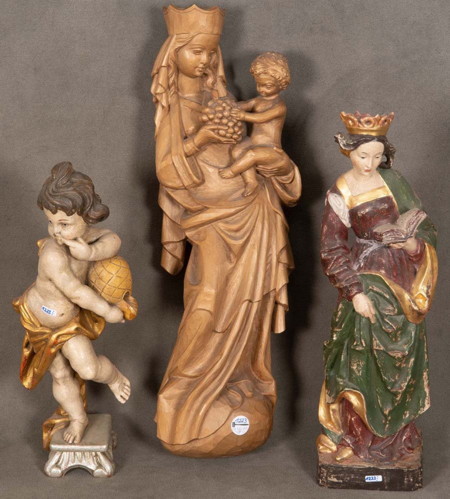 Drei Holzfiguren. Deutsch 20. Jh. Mutter Gottes mit Kind, Putto, hl. Katharina. Holz, geschnitzt,