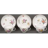 Drei Tassen mit Unterschalen. Meissen 1750. Porzellan, bunt bemalt mit Floraldekor ud