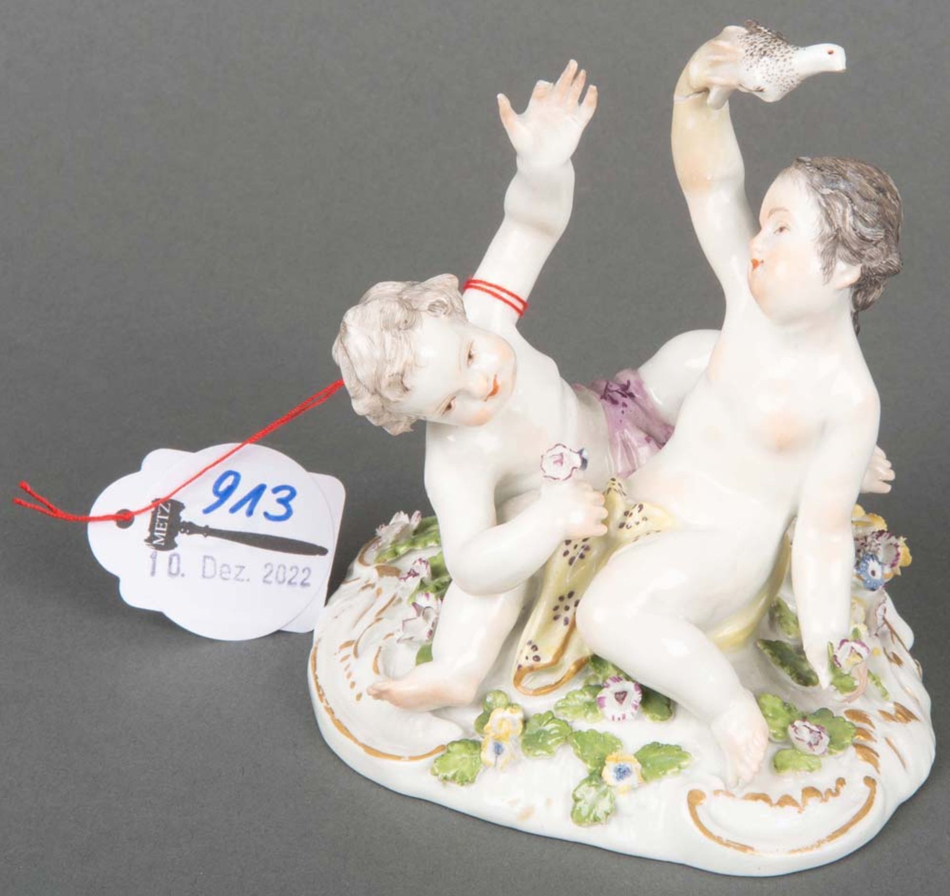 Sitzendes Puttenpaar. Meissen 1750. Porzellan, bunt bemalt, ohne Marke. Modell von J.J. Kaendler,