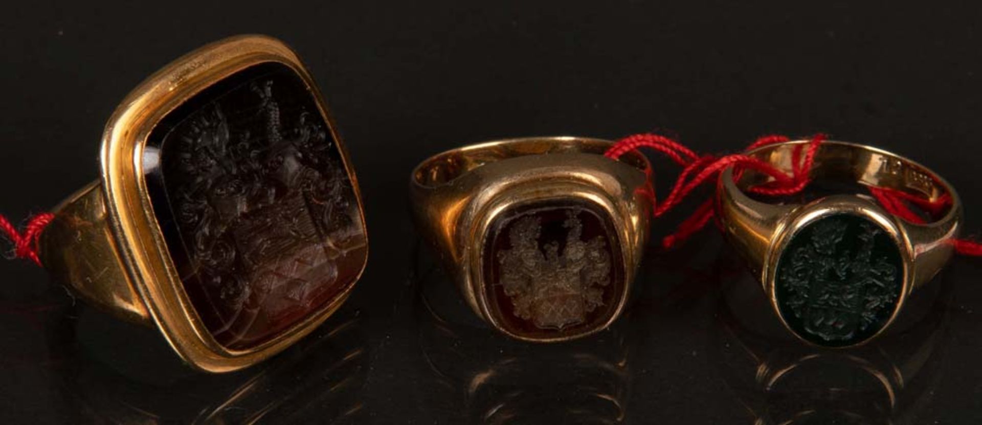 Drei Siegelringe. 14 ct Goldfassung, ca. 29 g. Besetzt mit Onyx / Topas.