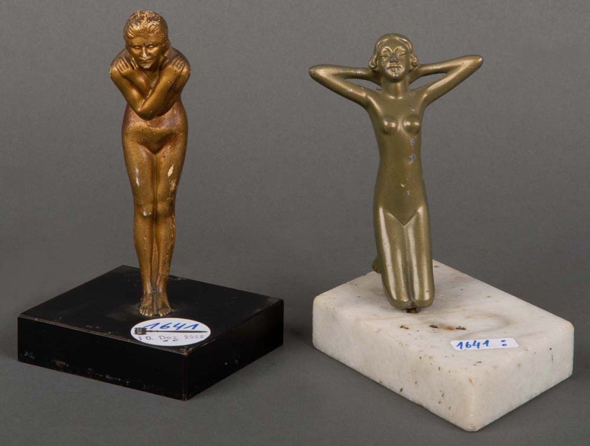 Zwei Frauenakte. Deutsch 20. Jh. Vergoldete Bronzefiguren, auf Marmorsockeln, kniend bzw. stehend,