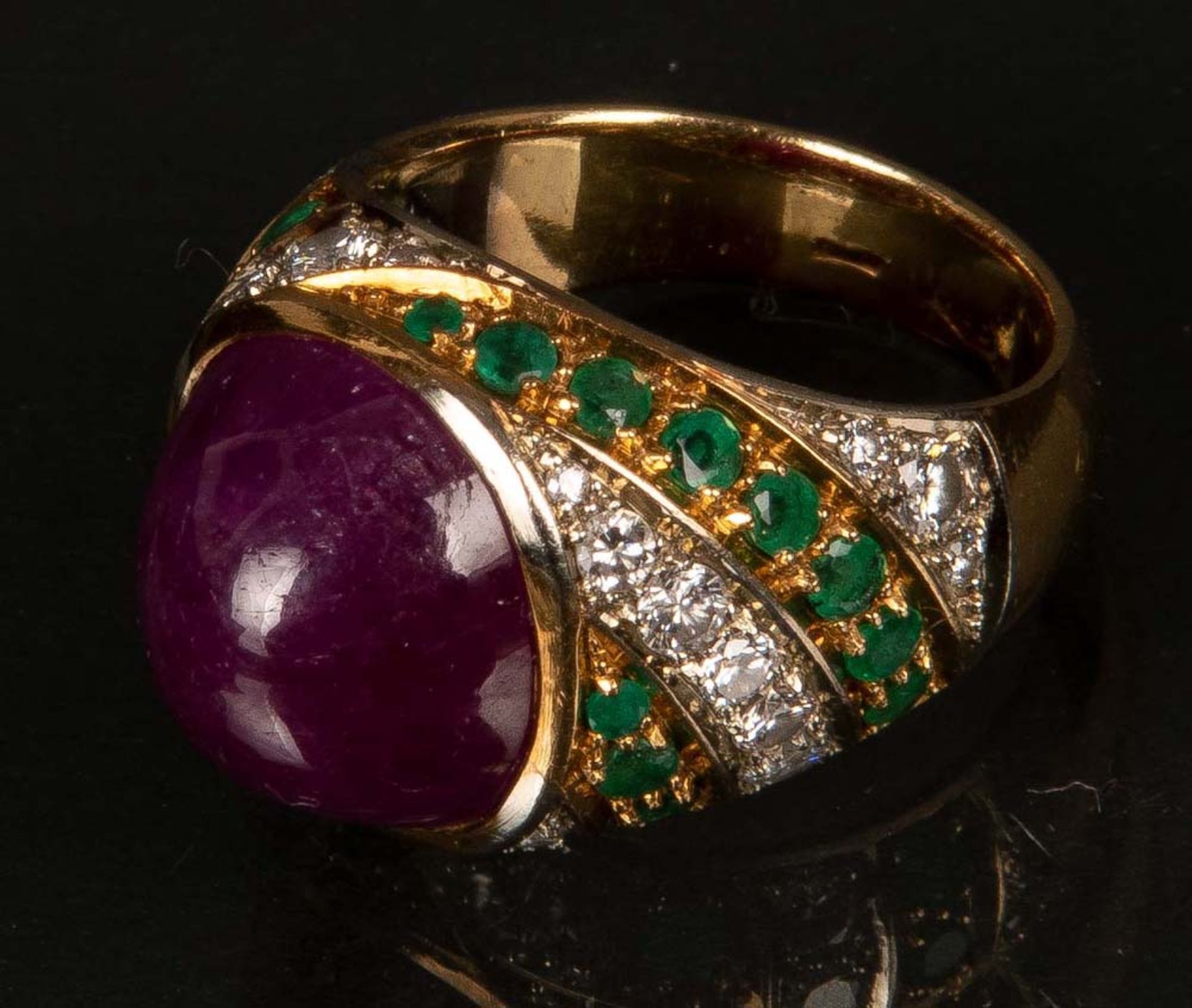 Damenring. 18 ct Gold, ca. 10 g. Besetzt mit Rubin-Cabochon, Smaragden und 24 Brillanten, ca. 0,75