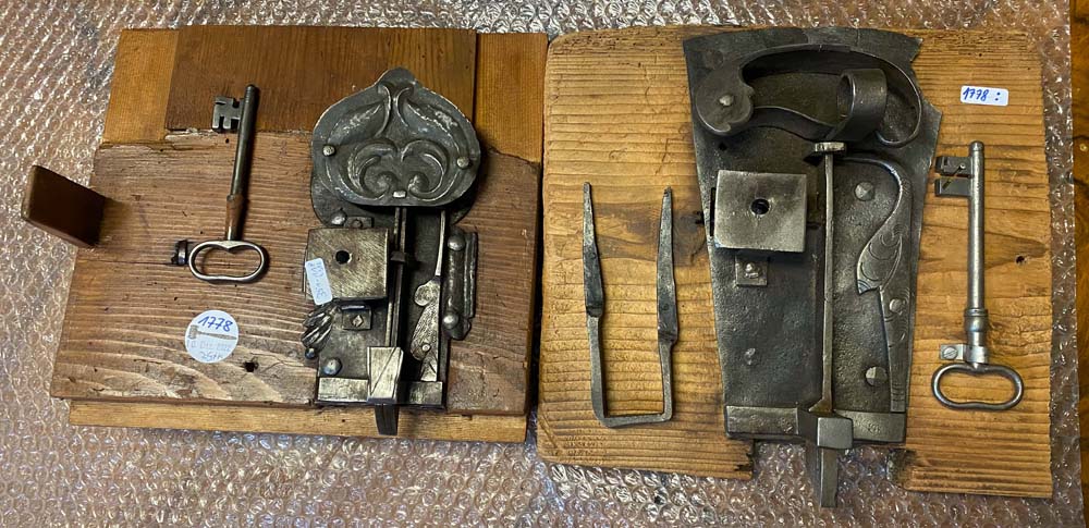 Zwei verschiedene Schlösser mit passendem Schlüssel, auf Holz genagelt. Dornmaß: 8,5 bis 10,5 cm. (