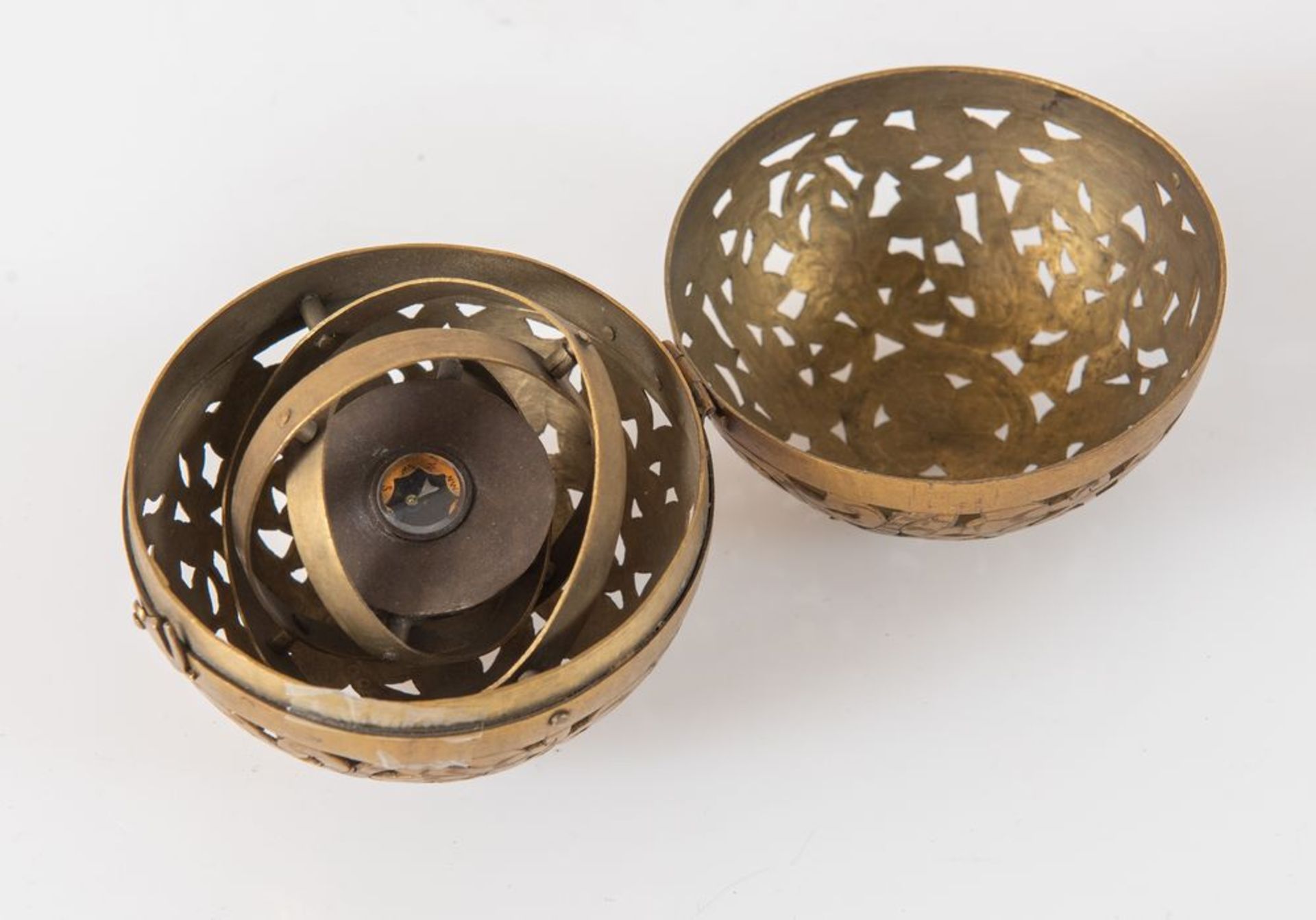 Antica bussola giroscopica racchiusa in sfera di bronzo traforata e incisa. Cm 7,5x8.