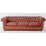 Divano modello Chesterfield in pelle rossa. Cm 66x222x91.