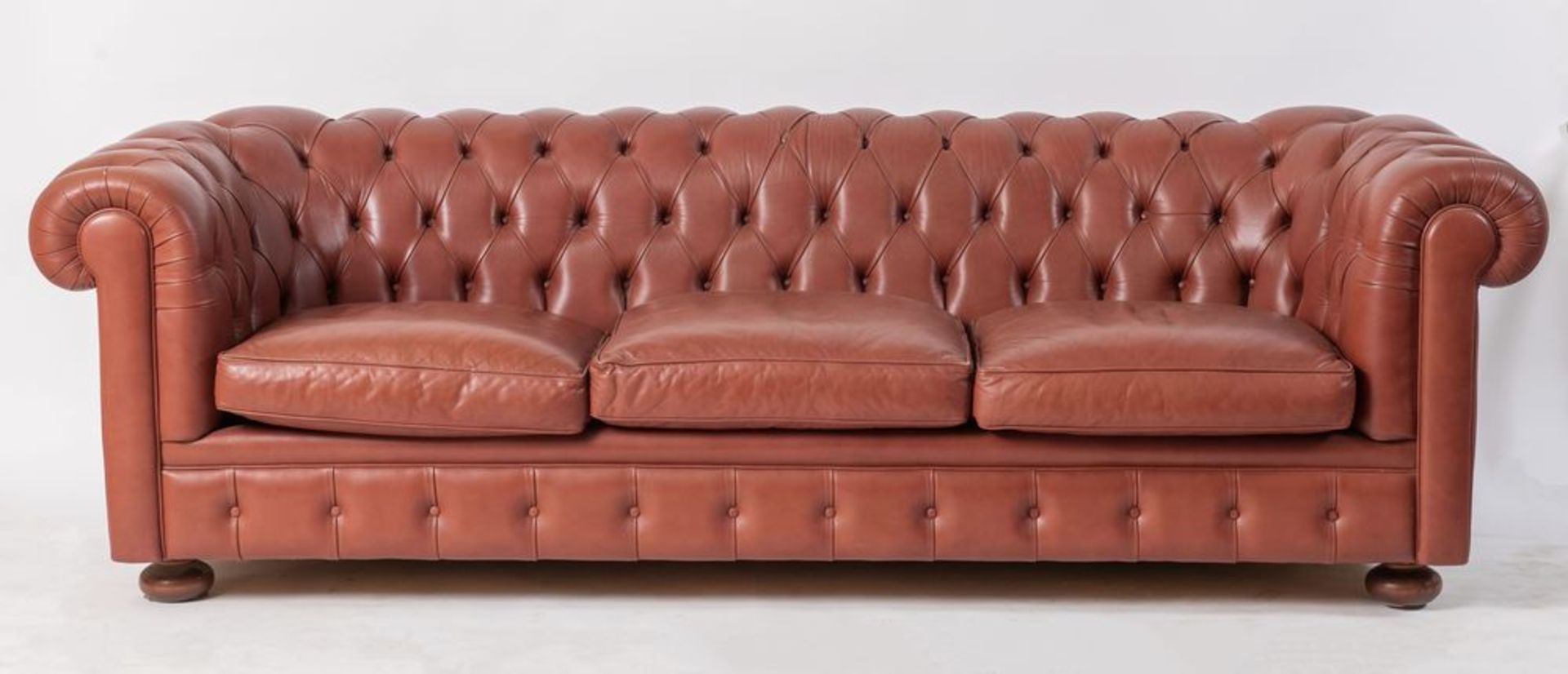 Divano modello Chesterfield in pelle rossa. Cm 66x222x91.