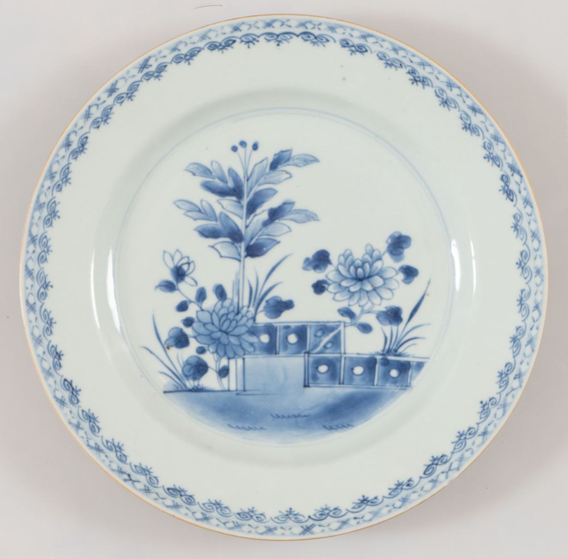 Piatto in porcellana monocroma blu con decoro di peonie e "cancelletto", su zolla erbosa. Cina, XVII