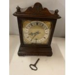 A DECORATIVE OAK CASED MANTLE CLOCK WITH GILT FACE AND ROMAN NUMERALS AND A KEY
