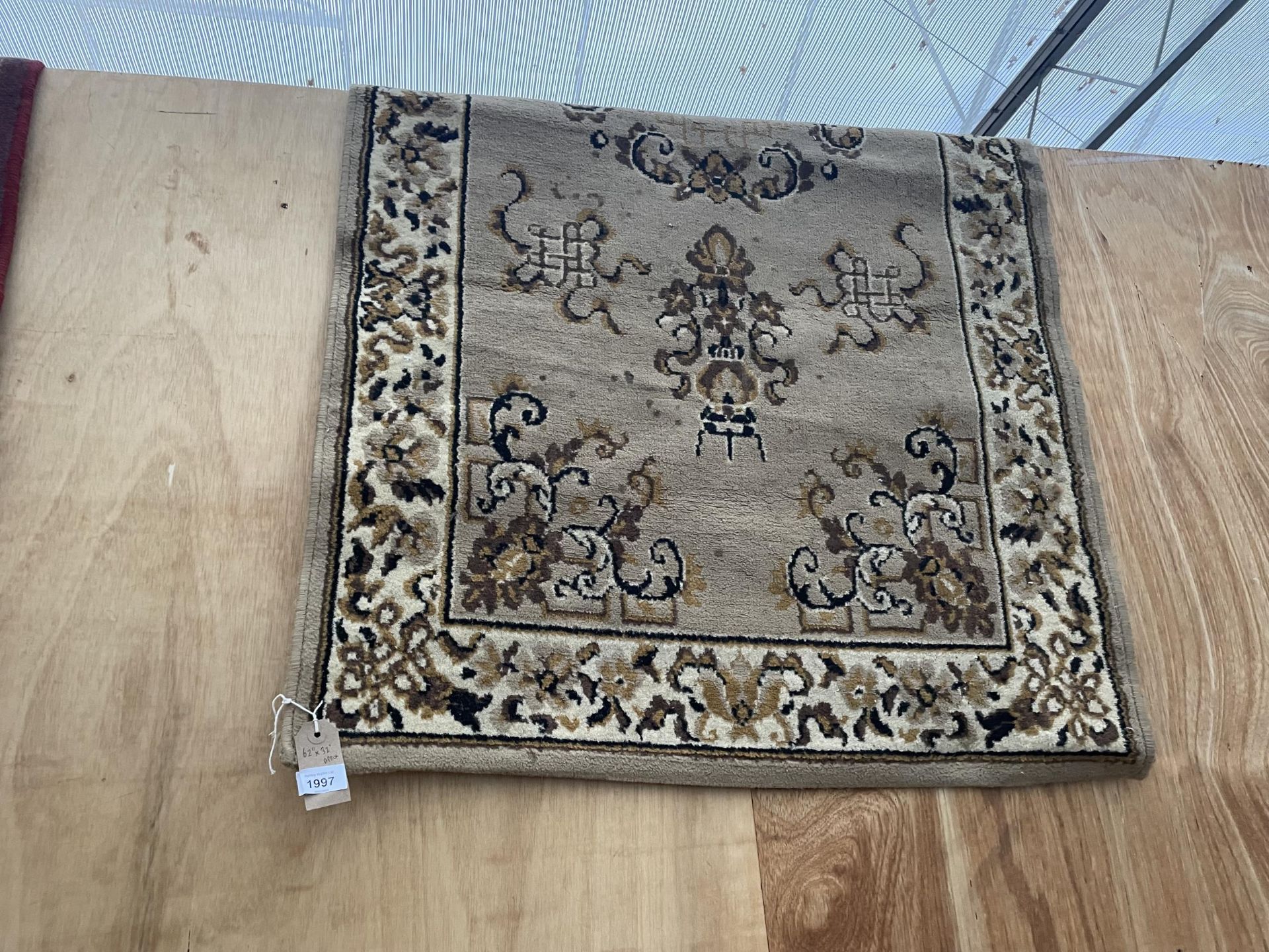 A BROWN FLORAL RUG APPROX 62 INCH X 32 INCH