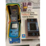 A CASED NINTENDO GAME BOY COLOR WITH TETRIS AND BUGS BUNNY GAME AND A PACMAN2 ELECTRONIC GAME
