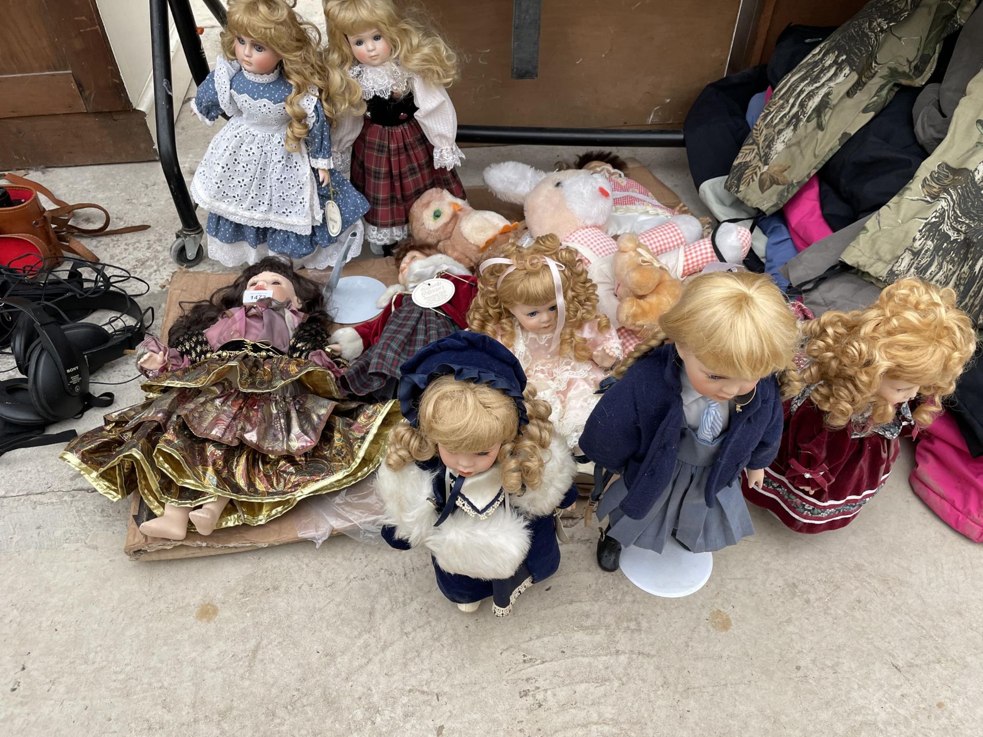 AN ASSORTMENT OF PORCELIN DOLLS AND TEDDIES ETC