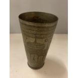 A BRASS DECORATIVE BEAKER WITH HAND ENGRAVED DESIGN DEPICTING AN ASIAN TEMPLE AND FLOWERS, HEIGHT