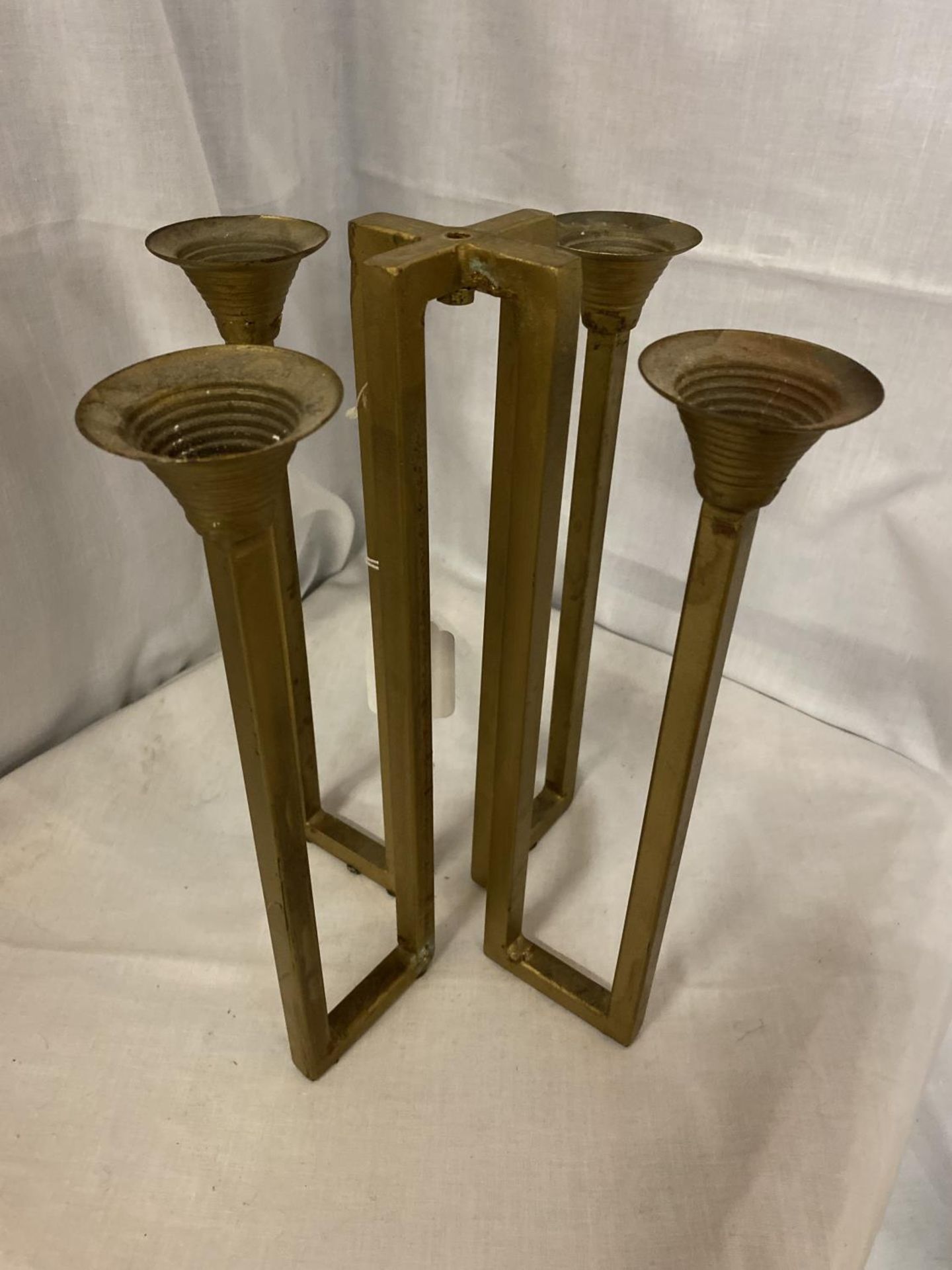 A BRASS GOTHIC STYLE FOUR BRANCH CANDLESTICK