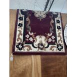 A PURPLE FLORAL RUG APPROX 56 INCH X 28 INCH