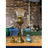A LARGE BRASS OIL LAMP WITH COLUMN STAND AND FLUTED GLASS SHADE AND ANOTHER WITH TURQUOISE AND