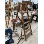 A SET OF VINTAGE WOODEN STEP LADDERS AND A PAIR OF VINTAGE CAST IRON TRESSTLES