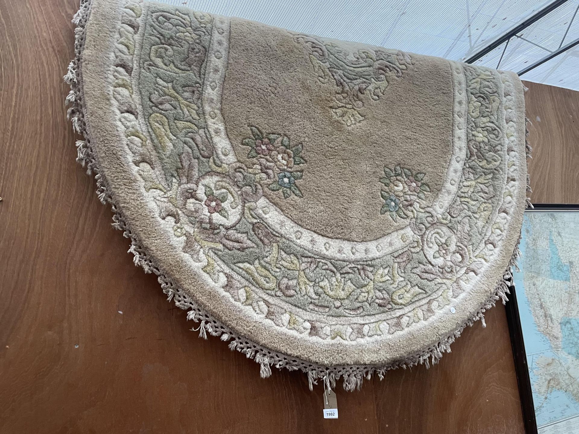 AN OVAL CREAM PATTERNED RUG