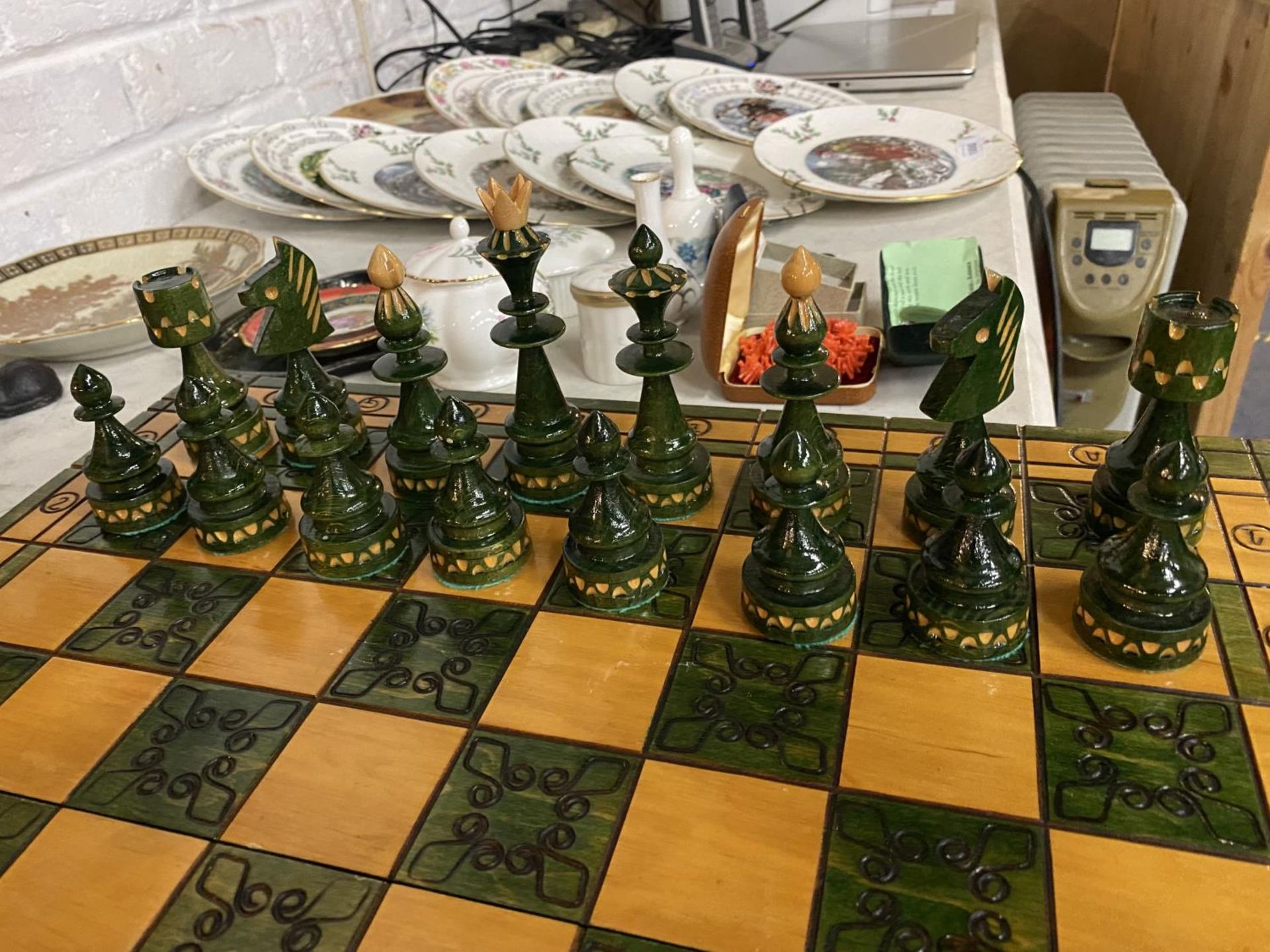 A GREEN AND WHITE WOODEN CHESS SET AND PIECES WHICH FOLDS AWAY