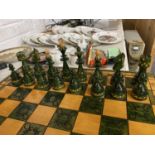 A GREEN AND WHITE WOODEN CHESS SET AND PIECES WHICH FOLDS AWAY